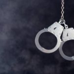 handcuffs-hanging-on- dark-bg